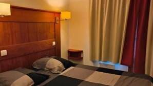 A hotel room with a large bed, two bedside tables, a headboard, and a window with curtains. - Résidence Le Rami Les Coches - La Plagne (La Plagne-Tarentaise)