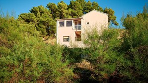A modern two-story house with a balcony, surrounded by dense greenery and trees. - Sun Spalato Hills 8 (Split)