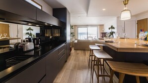 Une cuisine moderne dotée d’un îlot central, de tabourets de bar et donnant sur l’espace de vie.
