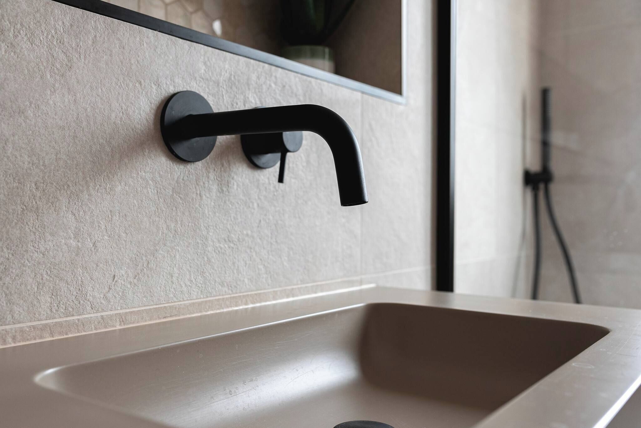 A modern bathroom with a minimalist sink and a sleek black faucet.
