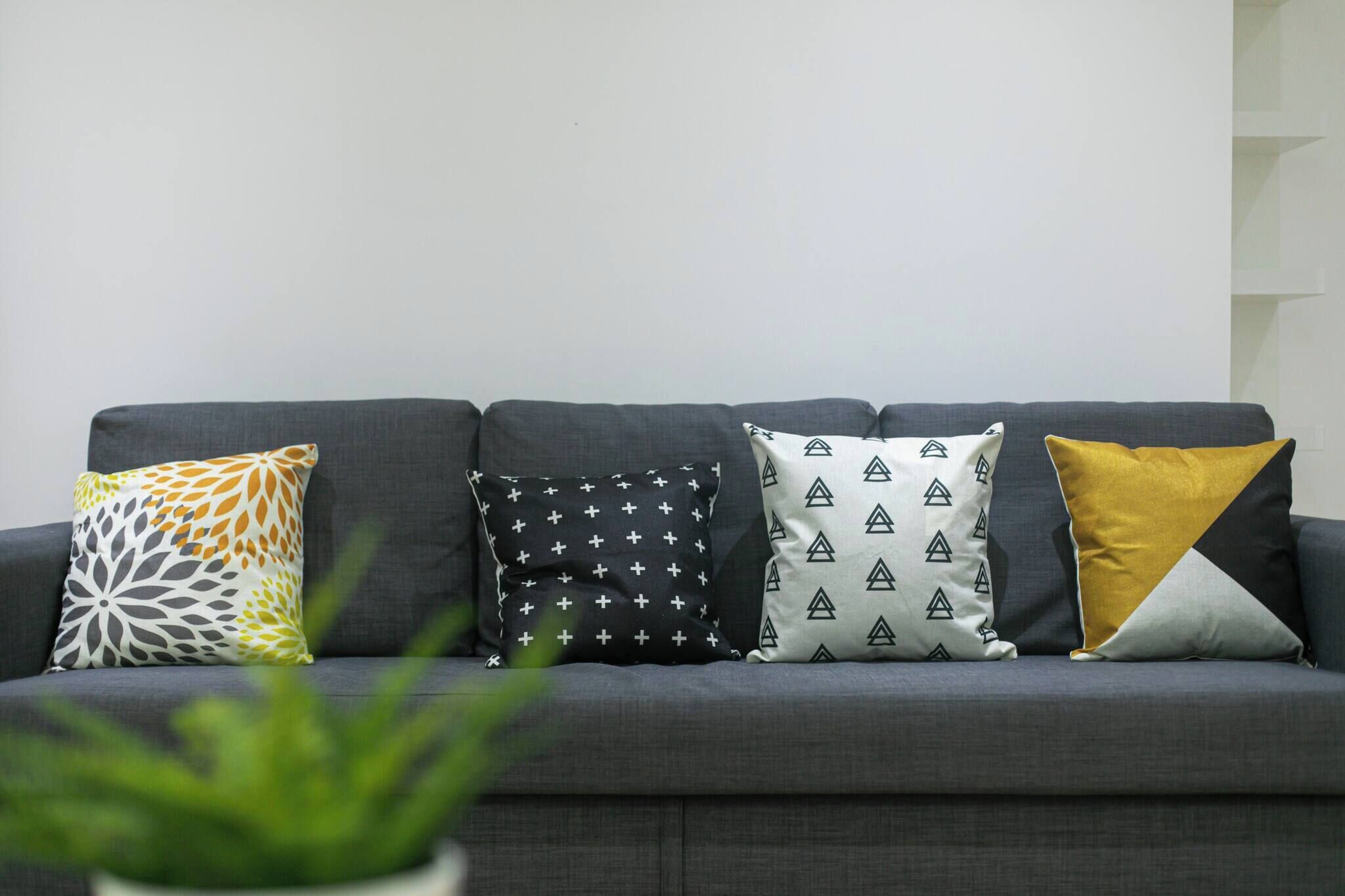 Ein graues Sofa mit vier gemusterten Kissen.