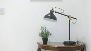 A desk lamp on a wooden table with a potted plant beside it. - Skyvillion - 1bed Flat In Kings Cross & St Pancras (London)