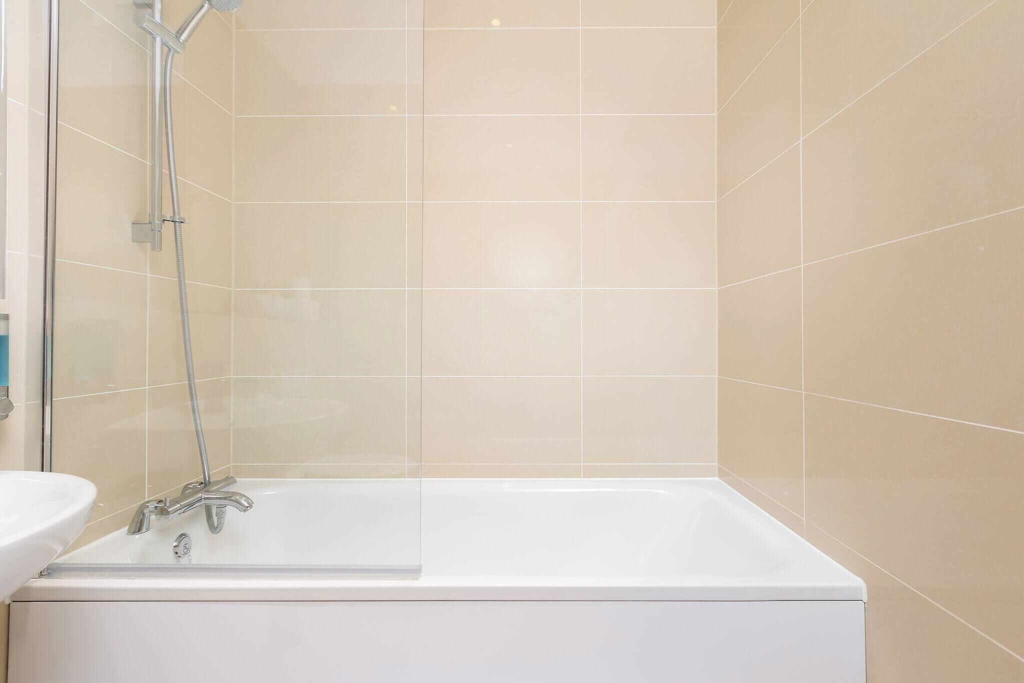 A bathroom with a bathtub, a shower, and a sink.