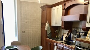 Une cuisine avec des meubles de rangement en bois, une table à manger et des chaises.