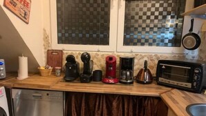 A kitchen with a dishwasher, a coffee maker, a toaster, and a window with checkered blinds. - 2 Zimmer Wohnung/zentral/bayernähe! (Leverkusen)