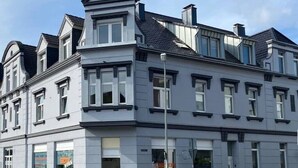 A multi-story building with a symmetrical facade, large windows, and a flat roof. - 2 Zimmer Wohnung/zentral/bayernähe! (Leverkusen)