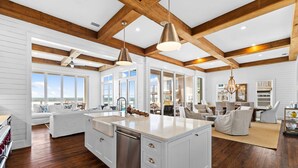 A spacious kitchen with a large island, wooden beams, and a view to the outside. - Gulf Front w/ Pool, LSV and Beach Boardwalk (Santa Rosa Beach)