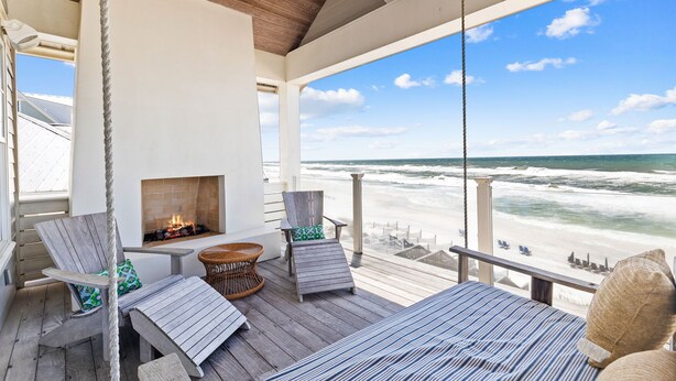 A wooden deck with a fireplace, seating, and a view of the beach. - Gulf Front w/ Pool, LSV and Beach Boardwalk (Santa Rosa Beach)