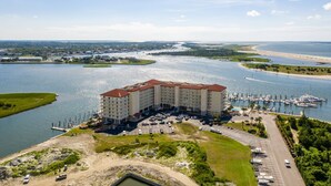 A large hotel with multiple floors, a marina with boats, and a waterfront view.