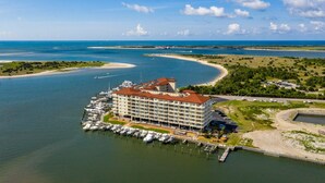 A large hotel with multiple floors and a marina with boats docked.