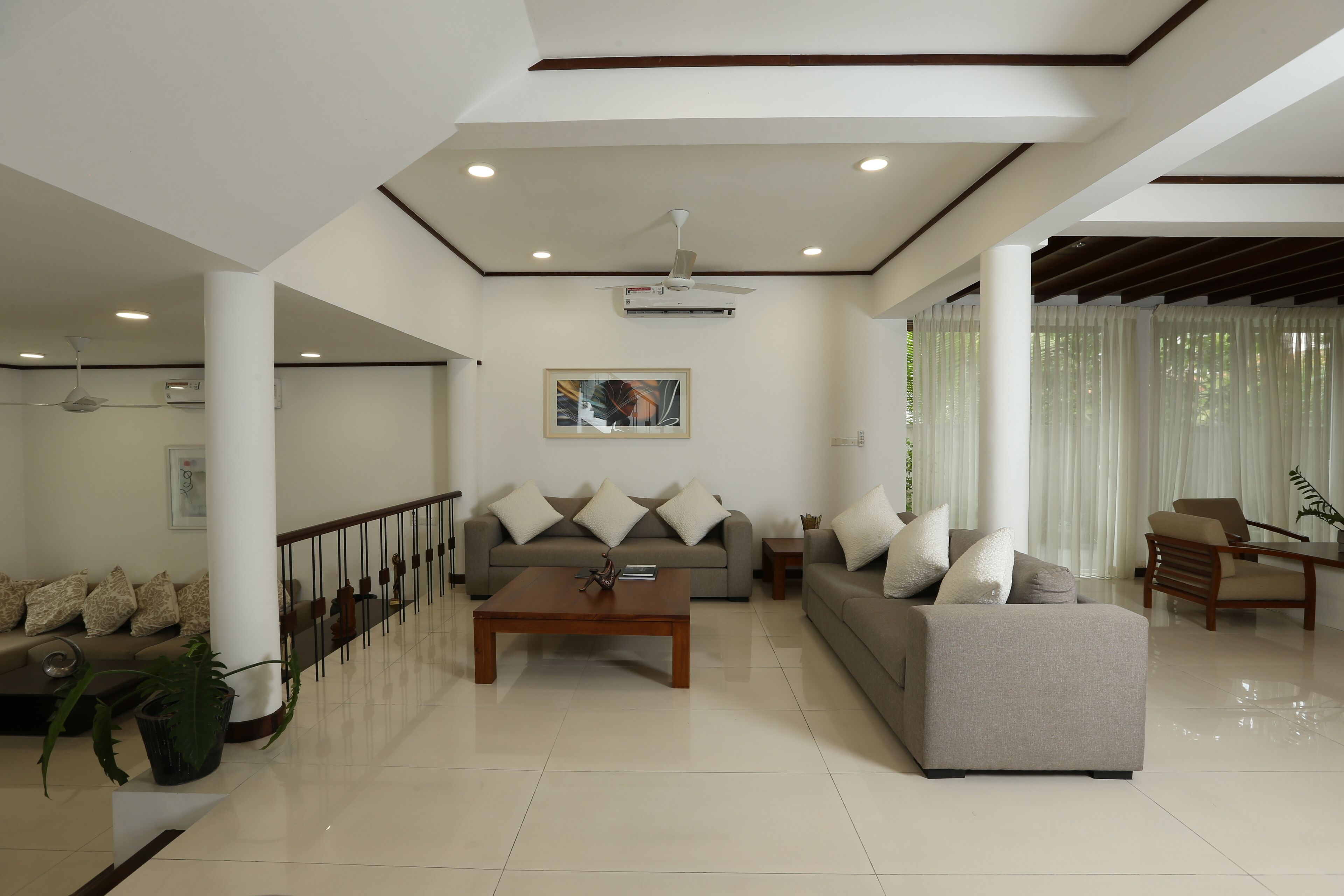 A spacious living room with a sofa set, a coffee table, and a dining area.