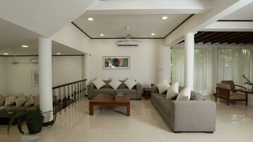 A spacious living room with a sofa set, a coffee table, and a dining area.