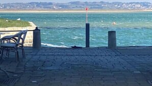 A paved walkway with chairs, a flagpole, and a view of the sea. - Maison Avec Plages et Commerces à Pieds (Batz-sur-Mer)