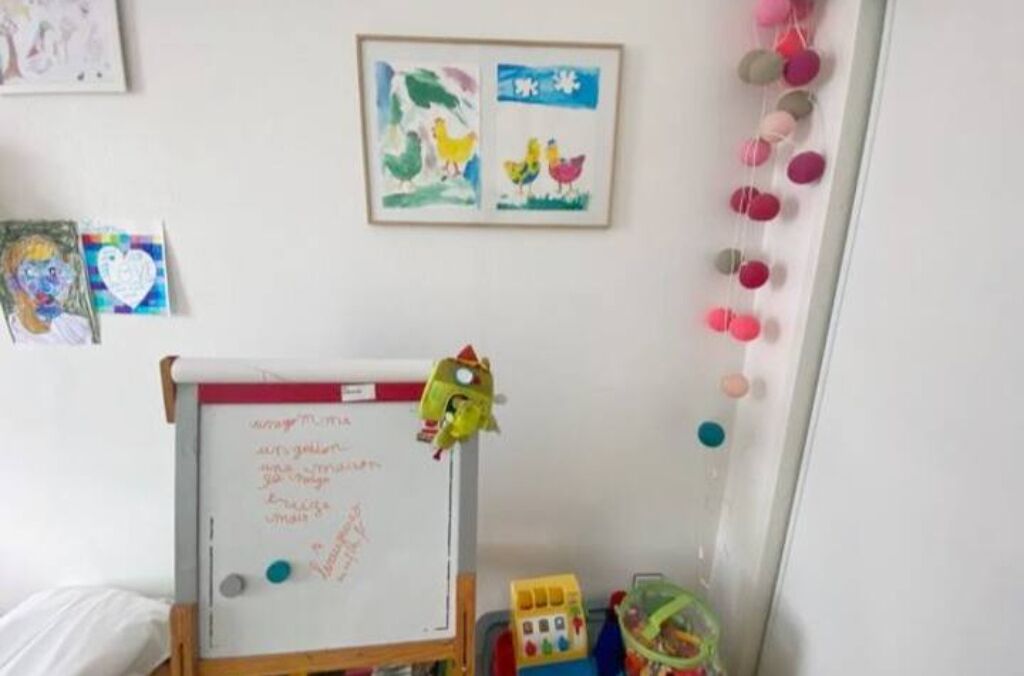 A classroom with a whiteboard, children's drawings, and educational toys.