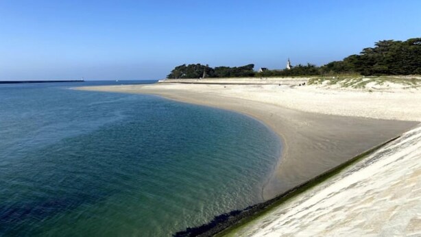 A beach with clear water, a sandy shore, and a lighthouse in the distance. - Maison Avec Plages et Commerces à Pieds (Batz-sur-Mer)