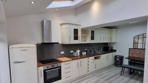 A compact kitchen with white cabinets, a built-in oven, and a small refrigerator.