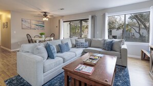 A living room with a sectional sofa, a coffee table, and a dining area with chairs and a table. - 54 Forest Gardens: Serene and Relaxing Villa, Walk to Beach, Pool, Free Bikes (Hilton Head Island)