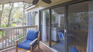 A covered outdoor area with a wooden deck, a ceiling fan, and a glass door leading to a patio. - 54 Forest Gardens: Serene and Relaxing Villa, Walk to Beach, Pool, Free Bikes (Hilton Head Island)