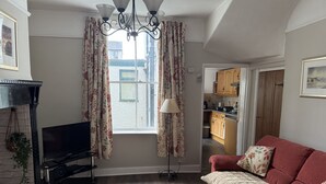 Una sala de estar con sofá, televisión y chimenea.