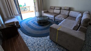 A living room with a sofa, a coffee table, and a patterned rug. - Magical Beachfront Apartments (Mombasa)