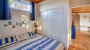 A bedroom with a bed, a wardrobe, and a window with curtains. - Chalet for 4 in Loctudy 500m from the beach (Loctudy)