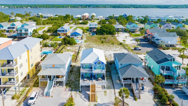 A coastal residential area with houses featuring balconies, a swimming pool, and a beach. - Gulf Shores Duplex | Shared Pool | Pet Friendly Beach Retreat (Gulf Shores)