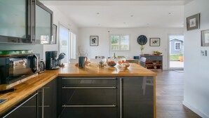 A modern kitchen with a wooden countertop, built-in appliances, and a view to the outside. - House with pool for 8 - 500m from the beach (Plobannalec-Lesconil)