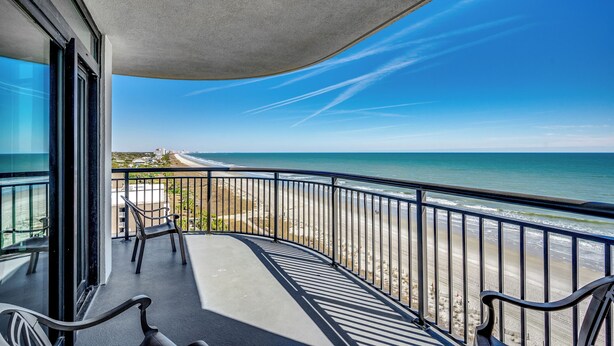 Ein Balkon mit Blick auf Strand und Meer.