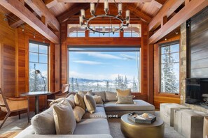 A cozy living room with a large window, a fireplace, and a wooden ceiling. - Unique Ridge Top Location by InvitedHome | Gondola, Hot Tub, O2, Ski-In/Out (Telluride)