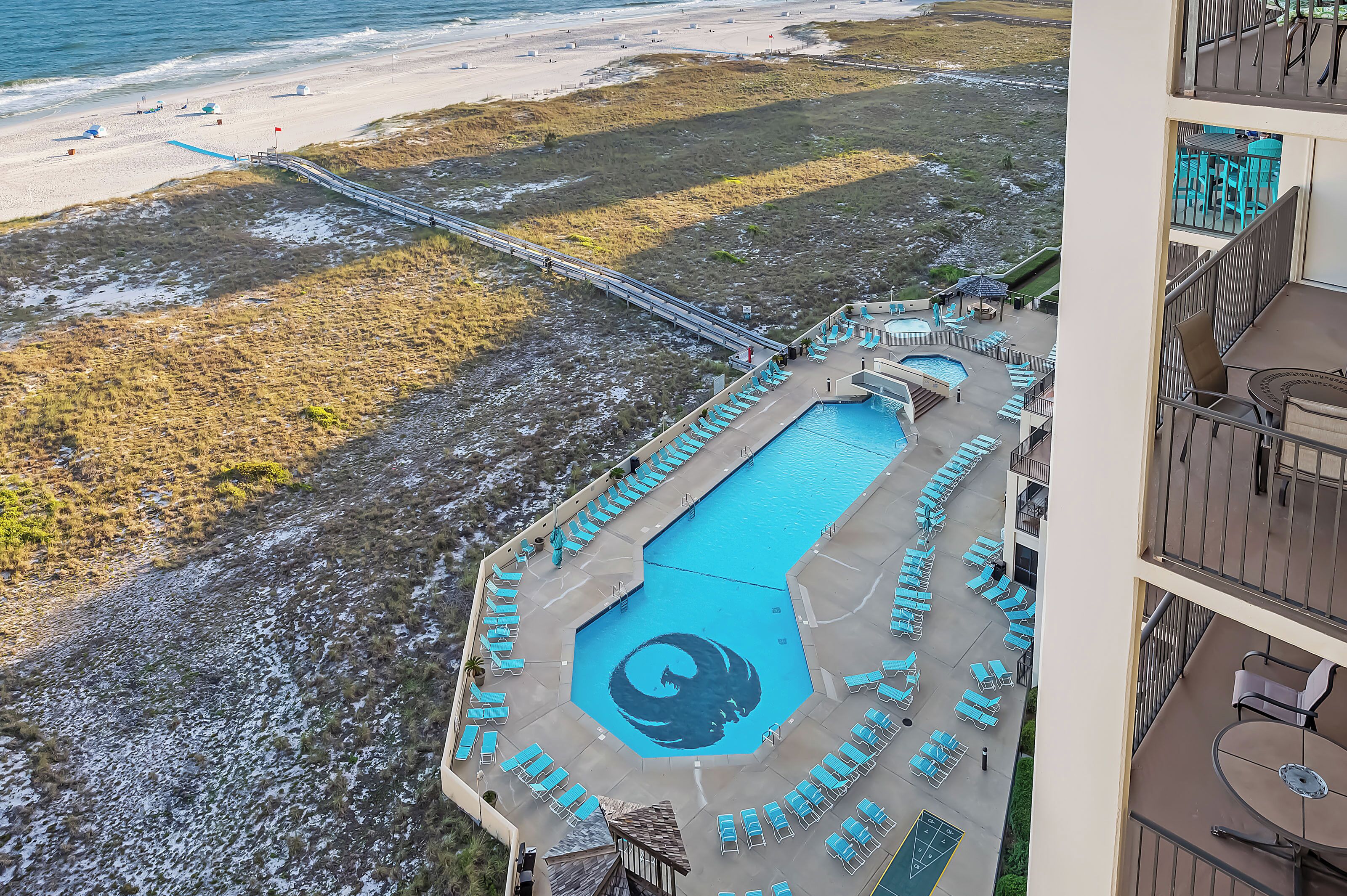 A resort with a swimming pool, beach access, and a view of the ocean.