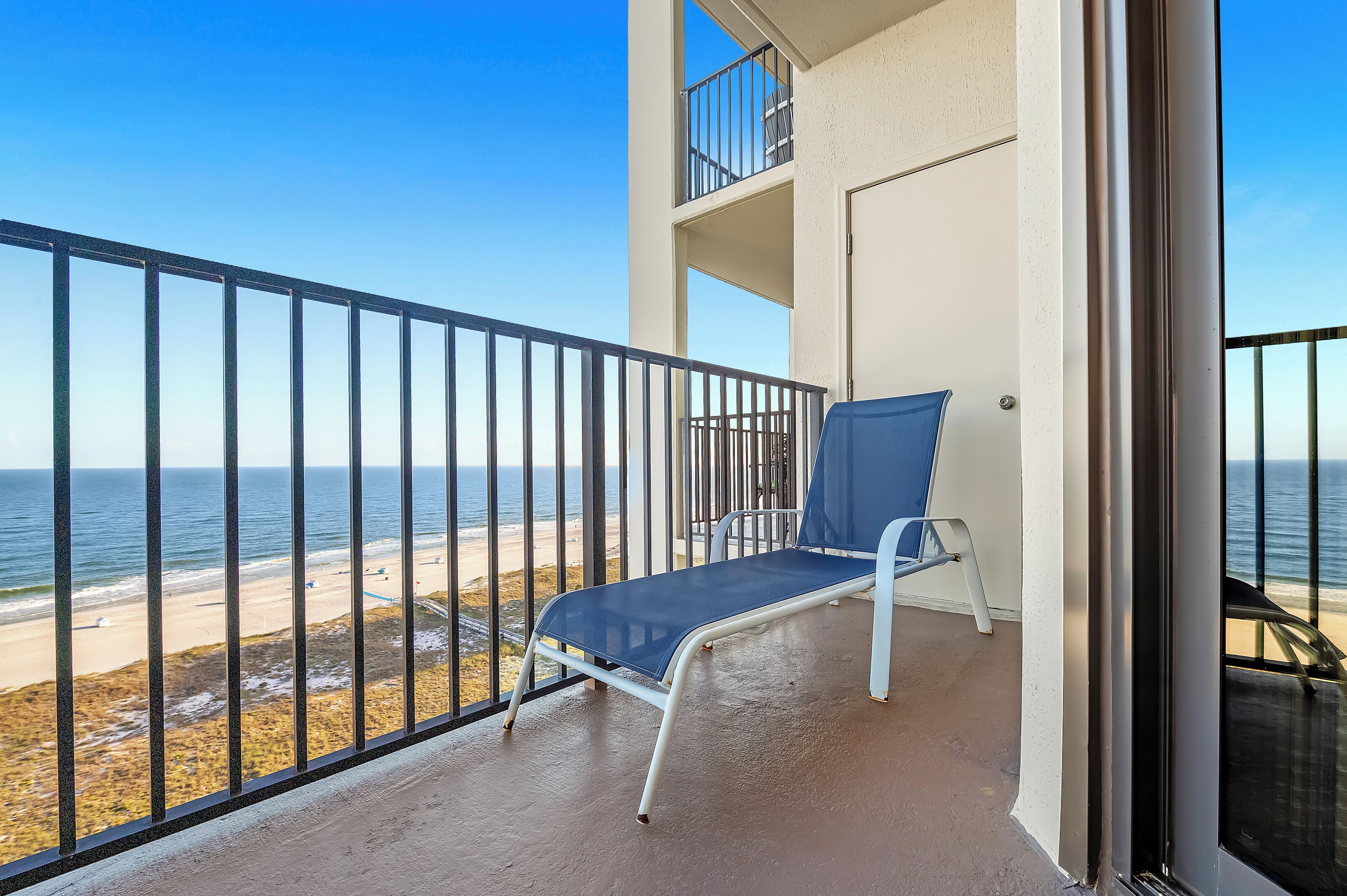 Un balcon avec vue sur la plage et l’océan.