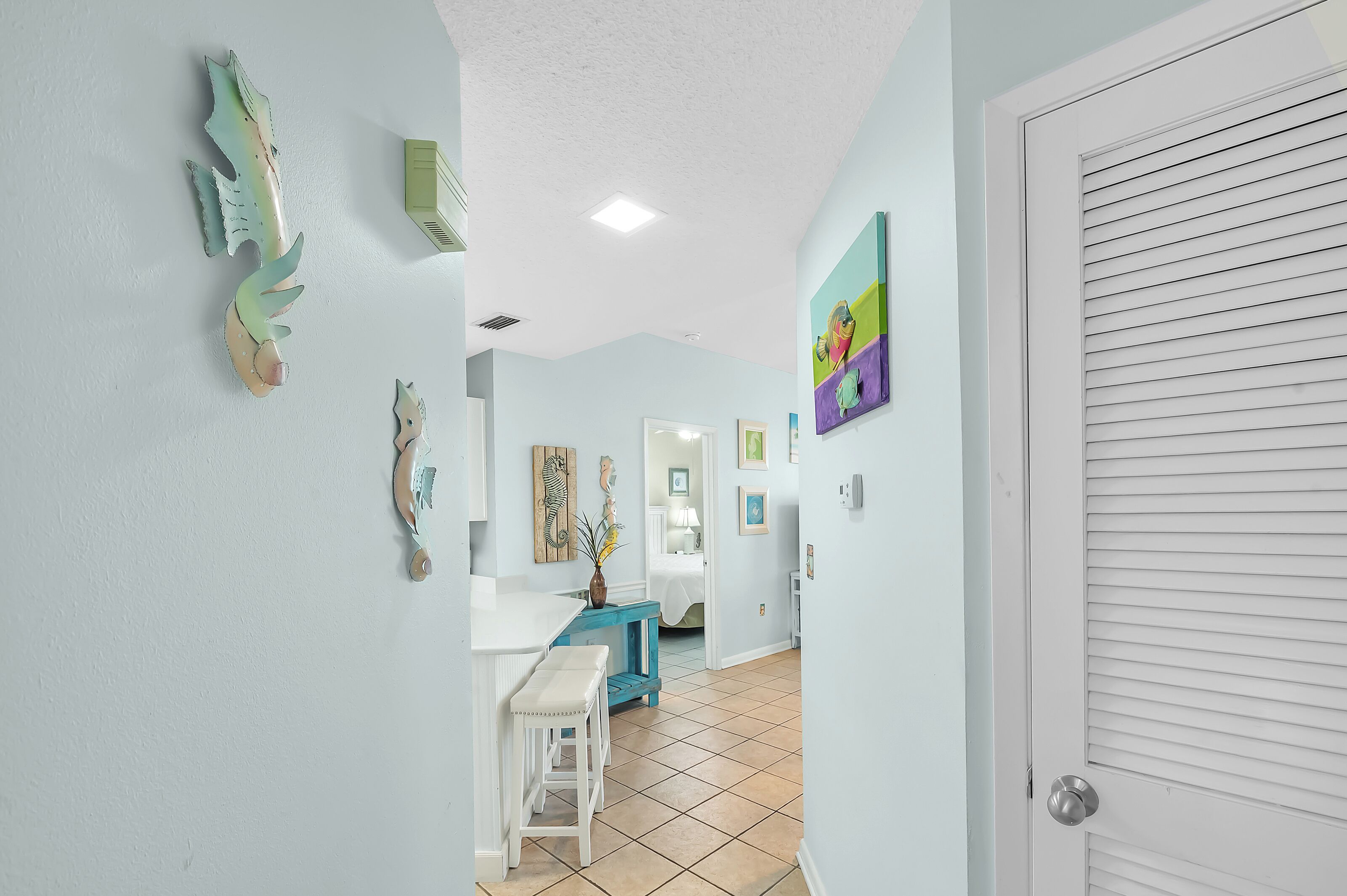 A hallway with a white door, a blue wall, and a white ceiling.