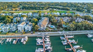 An aerial view of a coastal residential area with houses, a marina, and a golf course. - Moorings 510 - Yacht View Serenity! Top Floor! (Isle of Palms)