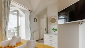 A hotel room with a bed, a TV, a dresser, and a window with curtains. - 2 Bed in Torquay (oc-w28110) (Torquay)