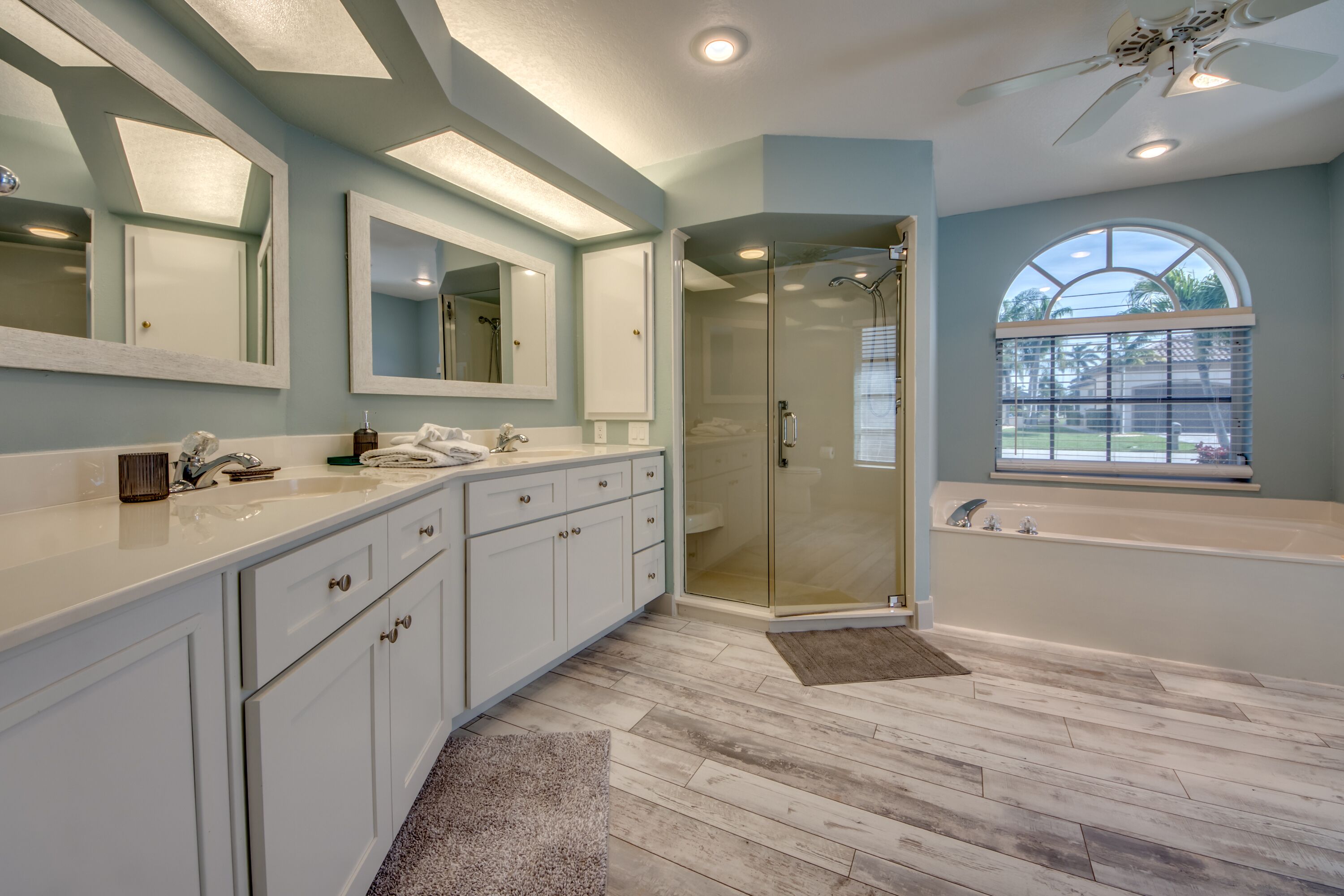 A modern bathroom with a large vanity, a walk-in shower, and a bathtub.