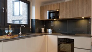 A modern kitchen with a built-in oven, a microwave, and a stainless steel kettle. - Capacity House · Central Tower Bridge Apartment (London)