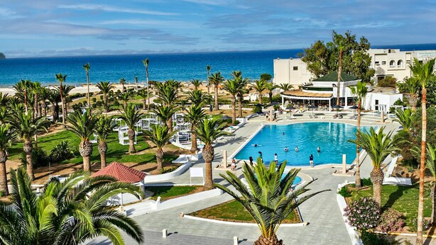A resort with a large pool, palm trees, and a view of the ocean. - Monarque El Fatimi Mahdia (Mahdia)