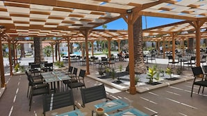 An outdoor dining area with wooden pergolas, tables, and chairs. - Monarque El Fatimi Mahdia (Mahdia)