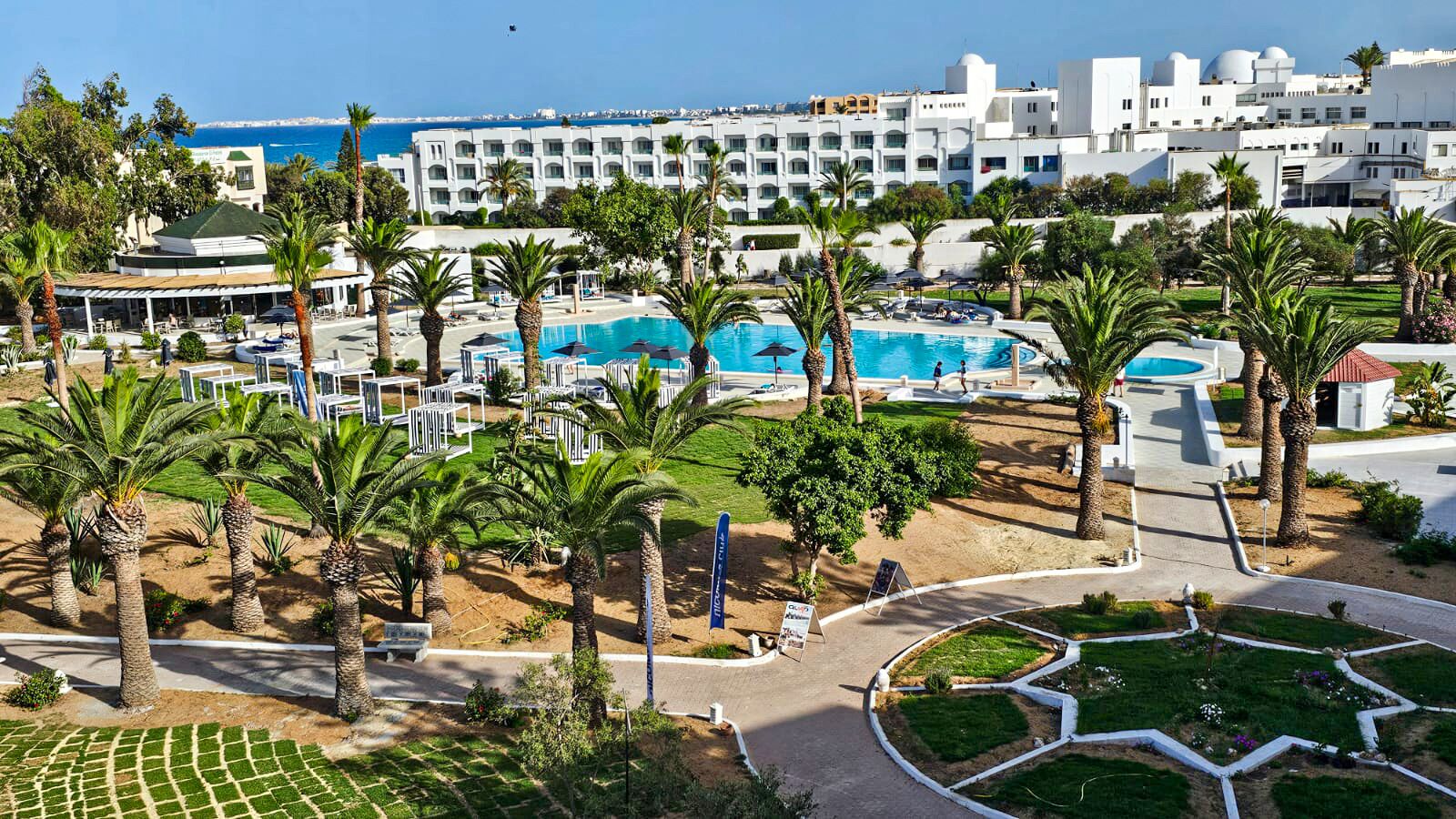 Ein Resort mit Swimmingpool, Palmen und Meerblick.