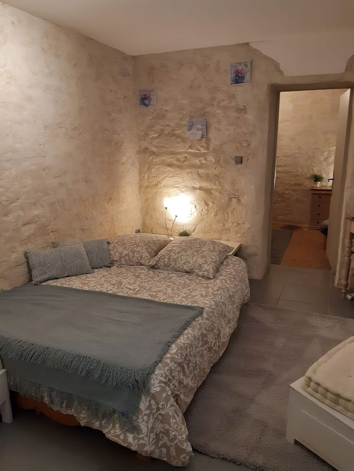A bedroom with a bed, a bedside table, and a nightstand.