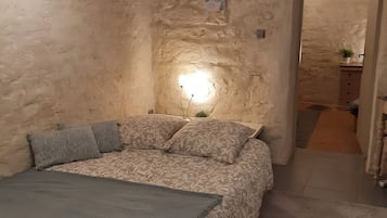 A bedroom with a bed, a bedside table, and a nightstand.