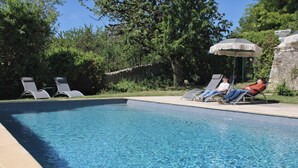 A swimming pool with lounge chairs and an umbrella. - Domaine Les Feuillants  (Crouzilles)