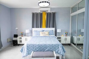 Relax in a serene bedroom with a neatly made bed, bedside table, and large wardrobe.