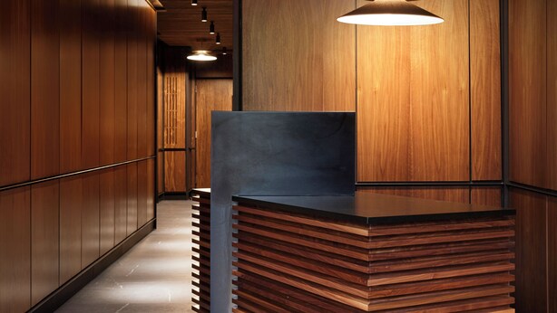 Una recepción de diseño moderno, paneles de madera en las paredes y piso de baldosas.