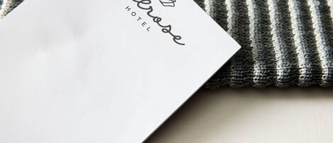Tarjeta de presentación de hotel en blanco con el nombre 'Melrose Hotel' y un logotipo.