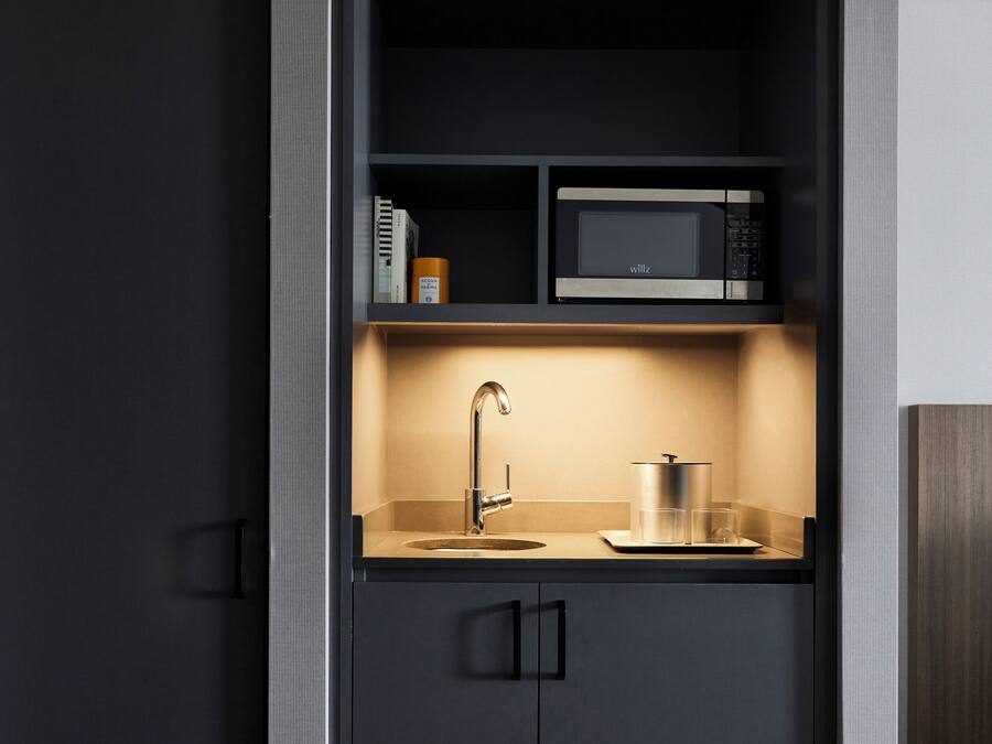 A compact kitchen with a built-in microwave, a sink, and a countertop.