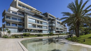 Un hôtel à plusieurs étages doté de balcons, d’une piscine et de palmiers.