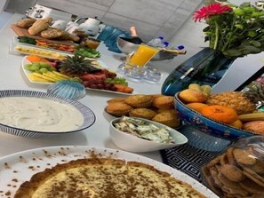 Ein Buffet mit verschiedenen Speisen, darunter Obst, Gemüse, Muffins und ein Kuchen.
