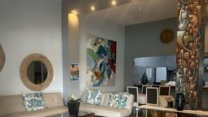 A modern living room with a sofa, coffee table, and artwork on the wall. - Ecolux Boutique Hotel Mozambique (Marracuene)