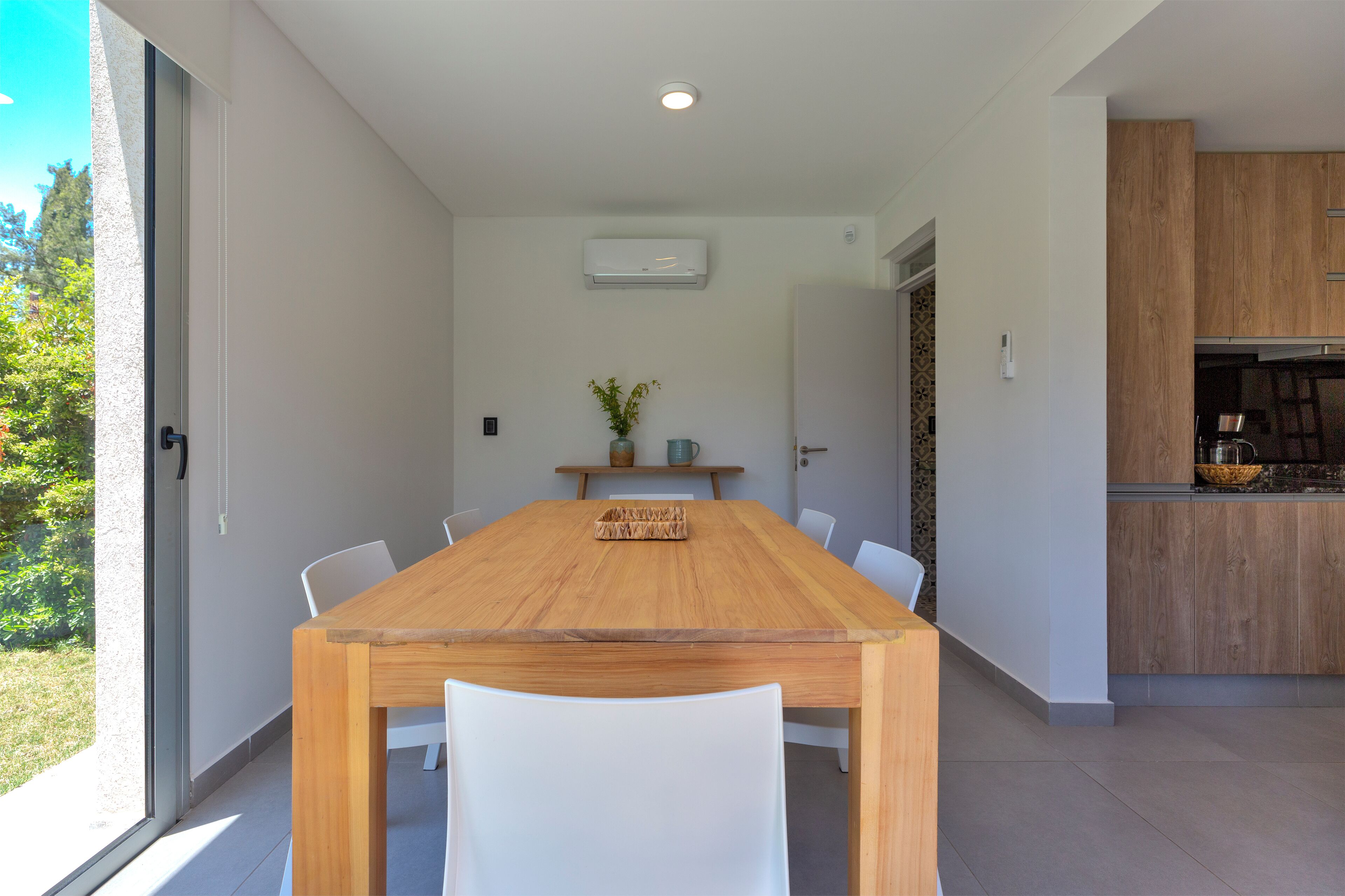 A modern kitchen with wooden cabinets, a built-in oven, and a large window.
